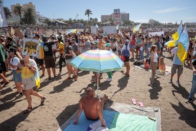 Bemused tourists surrounded by protestors on beach as Spanish locals call for change